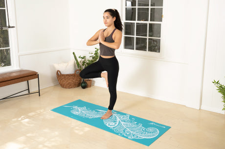Single leg pose on a yoga mat in a home gym