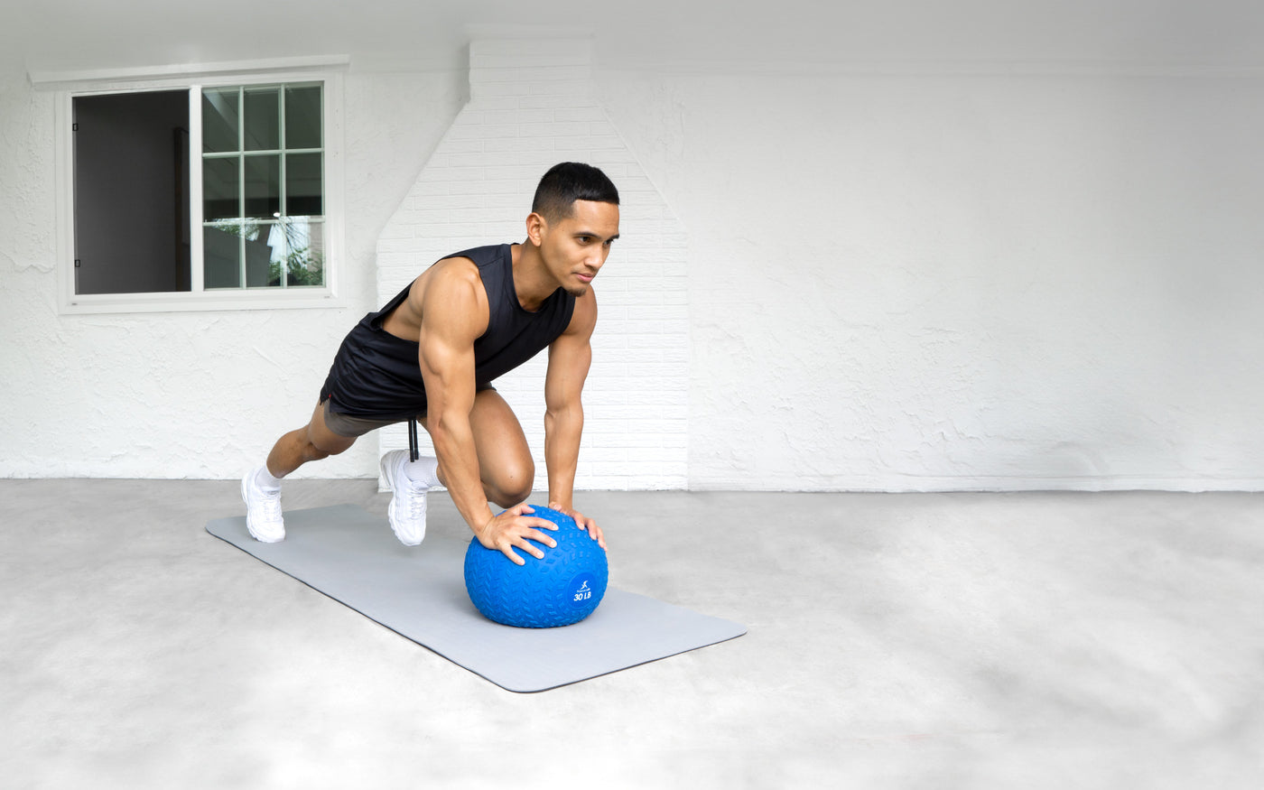 Man doing a mountain climber exercise on the floor with ProsourceFit Tream Slam Ball.