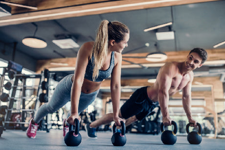couple working out with kettlebells at gym on valentine's day