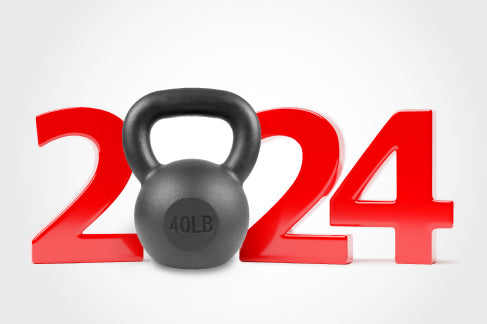 Black 40LB kettlebell placed in front of large red numbers forming ‘2024,’ symbolizing New Year fitness goals.